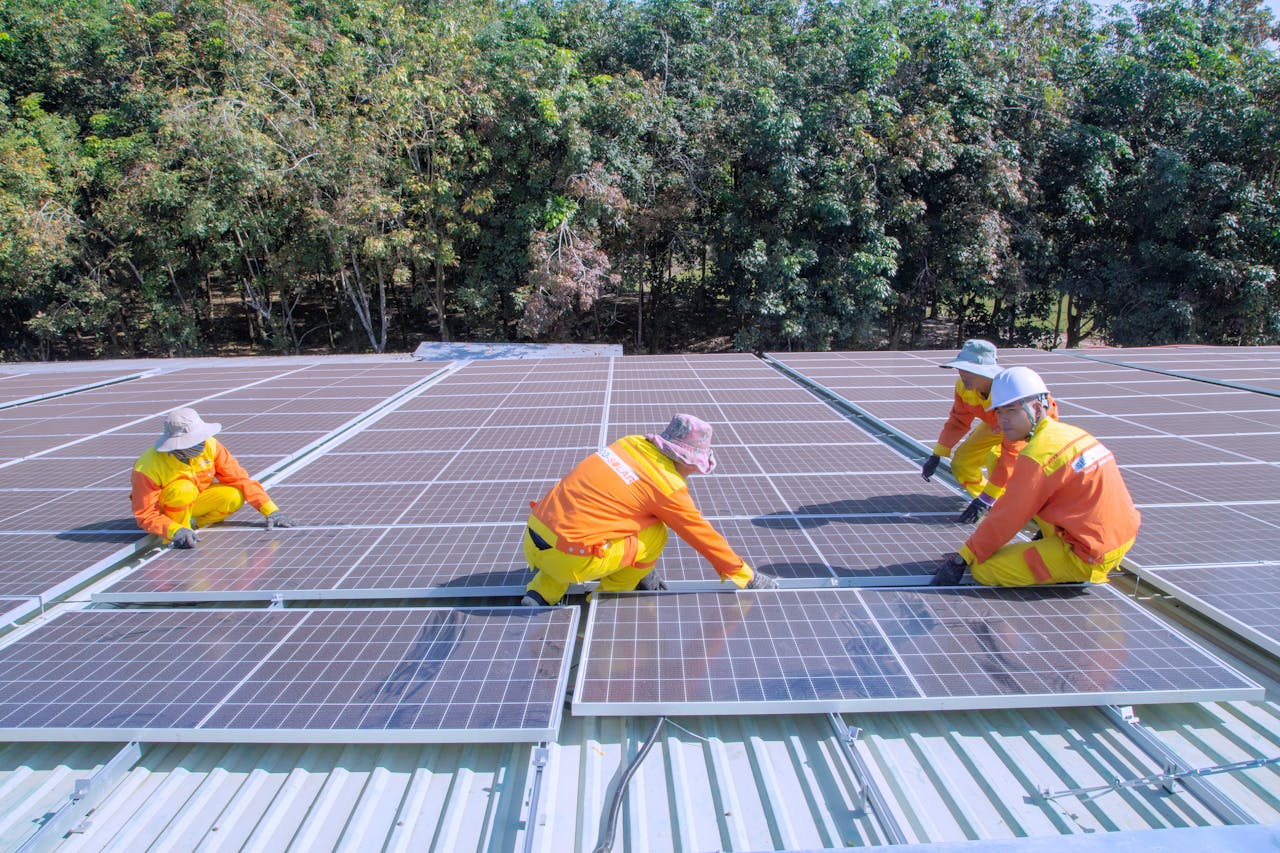Team of workers installing solar panels on a sunny day, promoting renewable energy and sustainability.